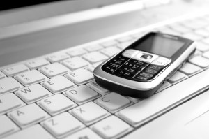 Business concept - mobile phone over laptop keyboard